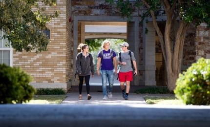 Three students walking on campus